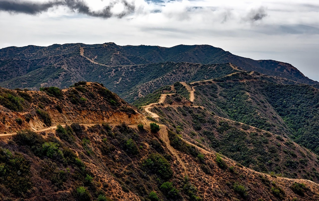 Dirt roads winding over brushy hills on Catalina Island under a cloudy sky