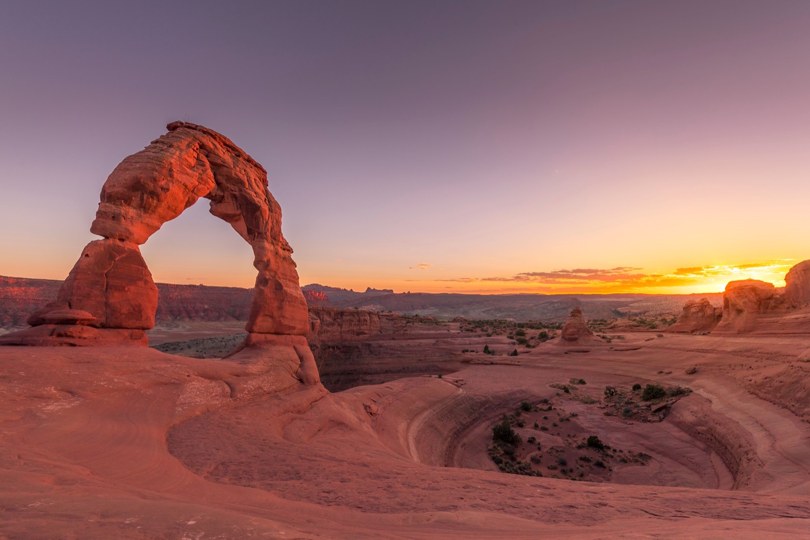 Delicate Arch glowing orange at sunset in Arches National Park